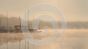 Early morning sunrise, boating on the lake in a huge fog