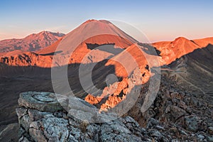 Early morning sunrise, landscape scenery of blue lake, wild mountains and huge volcano, autumn colours and golden sun rays.