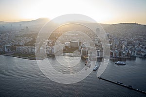 Early morning sunrise over city on Aegean coast.