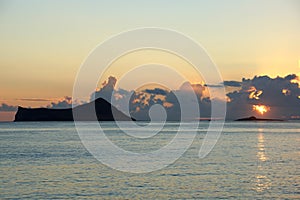 Early Morning Sunrise over Waimanalo Bay over Rock Island bursting through the clouds