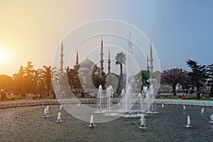 An early morning view of the Blue Mosque with its towering minarets, across the cascading fountains