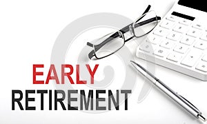 EARLY RETIREMENT Concept. Calculator,pen and glasses on white background