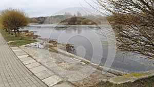 In early spring, during high water, the water in the river is high and muddy. The swift current floods the banks where there is a photo