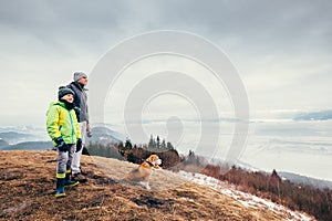 Early spring time - father with son walk with dog on mountain hi