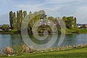 Early springtime green, lake, bell tower and church with modern architecture in district Drujba