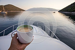 Early summer morning with cup of coffee cappuccino on a yacht in the Antisamos bay, Kefalonia island, Ionian sea, Greece