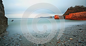 Tranquil waters lap up the beach at Charlestown, Cornwall photo