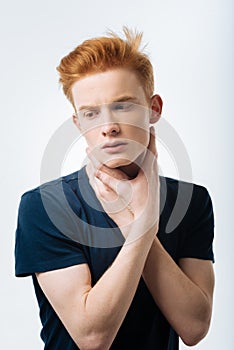 Earnest red-haired man looking down photo