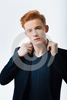 Earnest young man touching his collar photo