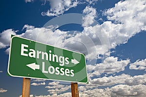 Earnings, Losses Green Road Sign Over Clouds photo