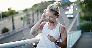 Earphones, fitness and young woman in city preparing for cardio race, competition or marathon training. Sports, exercise