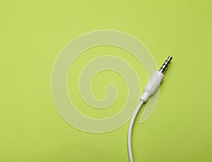 Earphones Mini Jack plug on green background