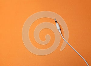 Earphones Mini Jack plug on orange  background