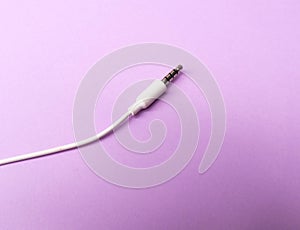 Earphones Mini Jack plug on purple  background