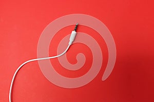 Earphones Mini Jack plug on red background