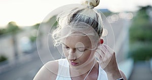 Earphones, sports and young woman in city preparing for cardio race, competition or marathon training. Fitness, exercise