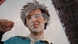 Earphones teen dancing street portrait. Young man listening music city closeup