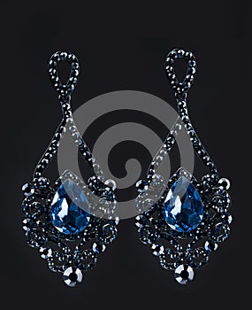 Earring with colorful blue gems on black