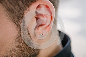 Earring in the male ear. Piercing Part of the body