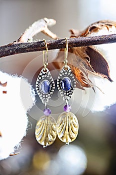Earrings with lapis lazuli stone, amethyst and glass bead, hanging on natural background