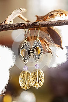 earrings with tyger eye stone, amethyst and glass bead, hanging on natural background