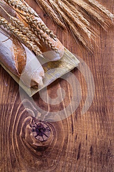 Ears of wheat and baguettes on vintage board with