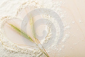 Ears of wheat in flour on a bread board, Cooked with love, heart