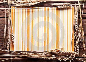 Ears of wheat in the form of frame on old wood.