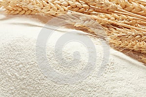 Ears of wheat on heap of flour