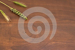 Ears of wheat and rye on wooden surface