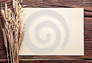 Ears of wheat and sheet of paper on old wood.