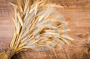 Ears of wheat on wooden background. Frame