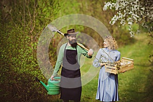 Earth concept. Image of two happy farmers with instruments. A farmer and his wife standing in their field. Farmers