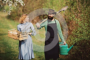 Earth concept. Image of two happy farmers with instruments. A farmer and his wife standing in their field. Farmers