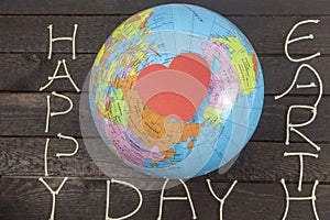 Earth Day concept. Heart paper card lays on globe