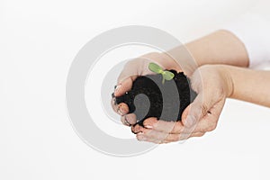 Earth day concept. Save planet. Hands holding ground with green fresh sprout on white background