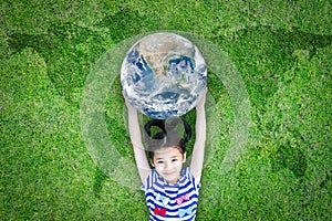 Earth day, ecological friendly and corporate social responsibility concept with kid raising world on green lawn