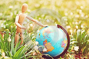 Earth Day. Save planet concept. Wooden puppet holding earth globe. World Environment Day concept