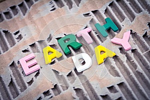 Earth Day wording on abstract brown torn cardboard background