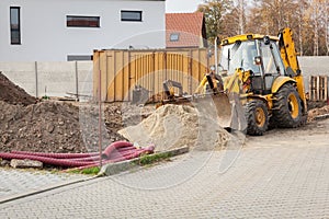 Earth excavation works by excavator at the construction of a house photo