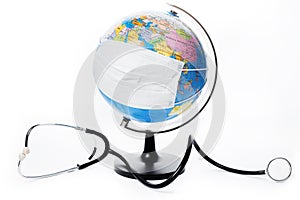Earth globe with antiviral surgical protective face mask and stethoscope on white background. Protect planet concept.