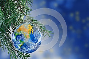 Earth globe as a Christmas bauble on fir branch, copy space