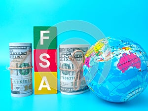 Earth globe and banknotes with word FSA