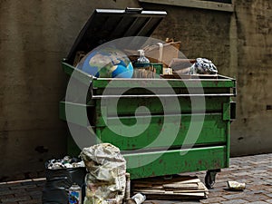 Earth globe in big dumpster with domestic trashes and wastes