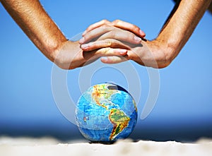 Earth globe with hands over it. Conceptual image