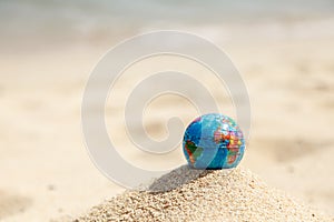 Earth globe on a hill of sand