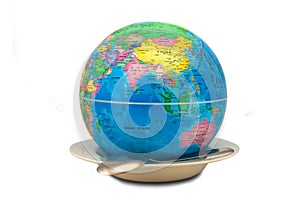 Earth globe inside an empty plate showing Asia and Australia as a concept of world hunger. The empty plate symbolizes the lack of