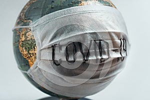 Earth globe with medical mask on white background, global pandemic covid-19, coronavirus