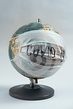 Earth globe with medical mask on white background, global pandemic covid-19, coronavirus