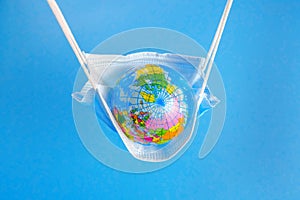 Earth globe in medicine mask to fight against Corona virus